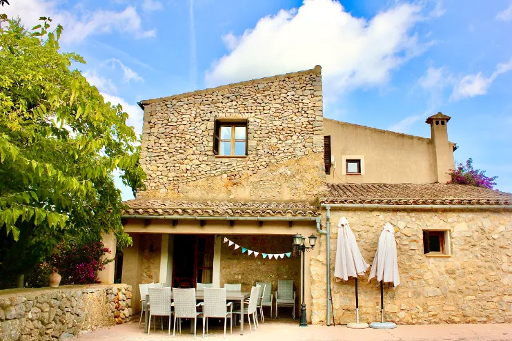Fachada rústica de piedra con terraza exterior soleada
