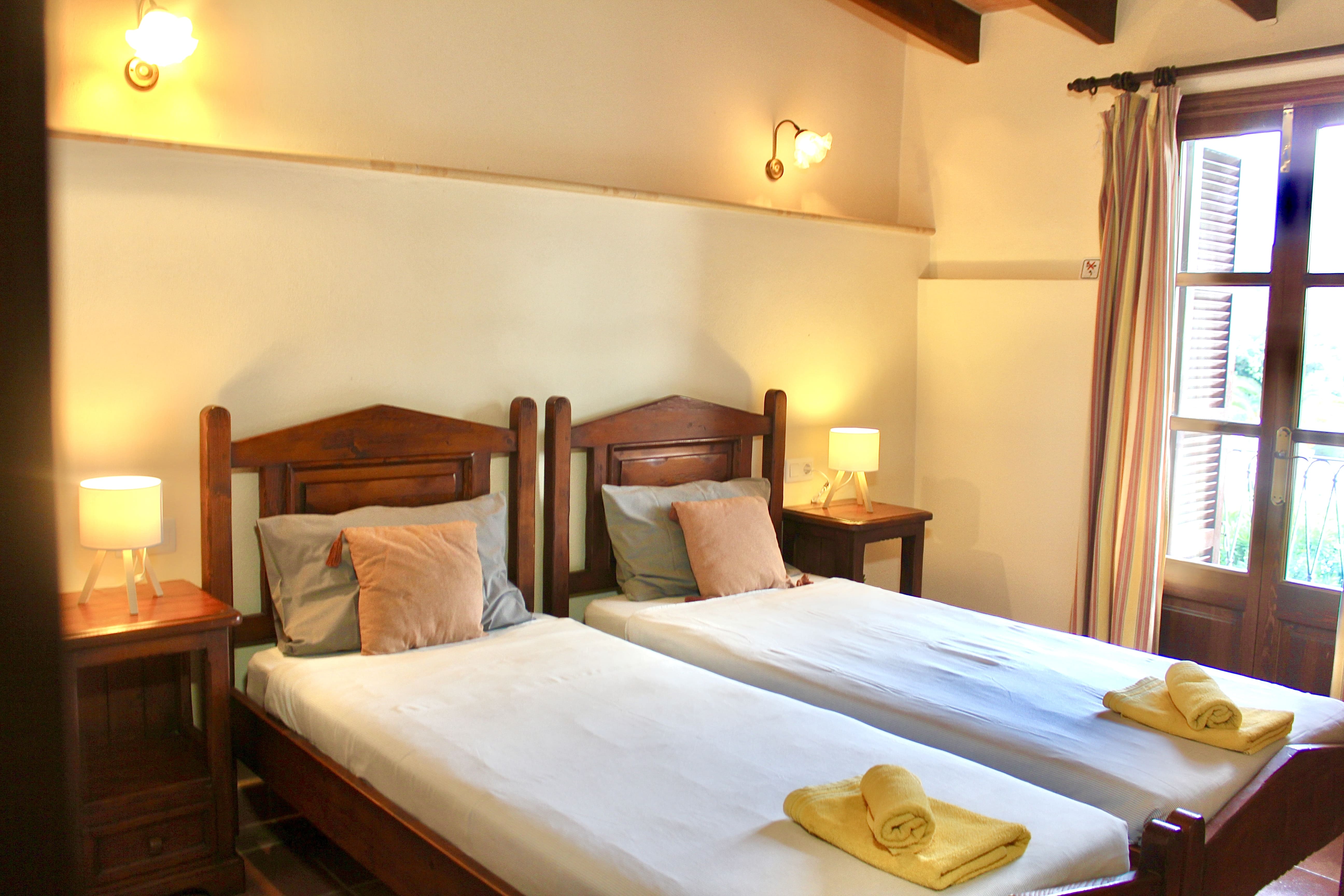 Dormitorio doble con dos camas individuales y balcón