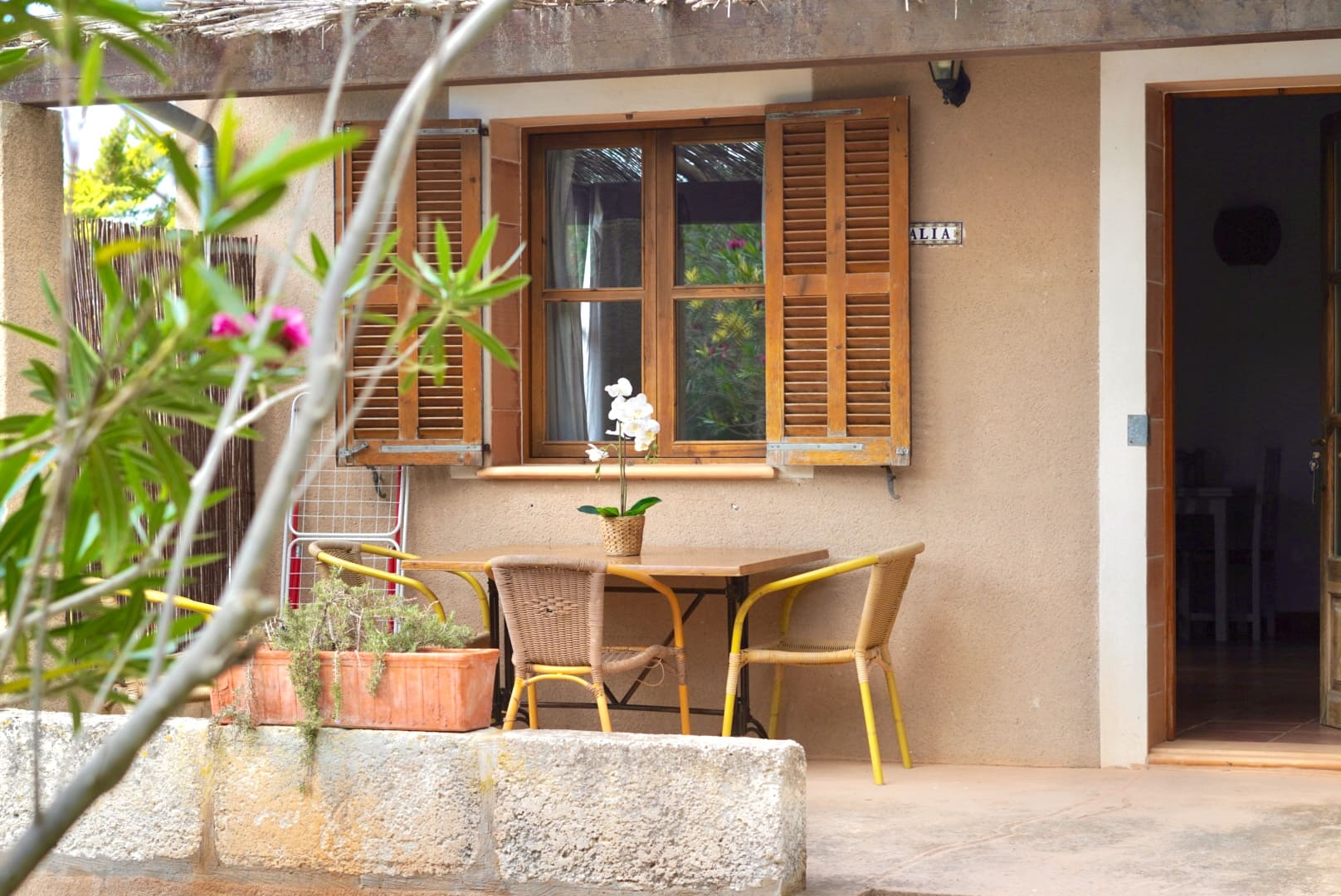 Porche exterior sombreado con mesa para desayunos al aire libre